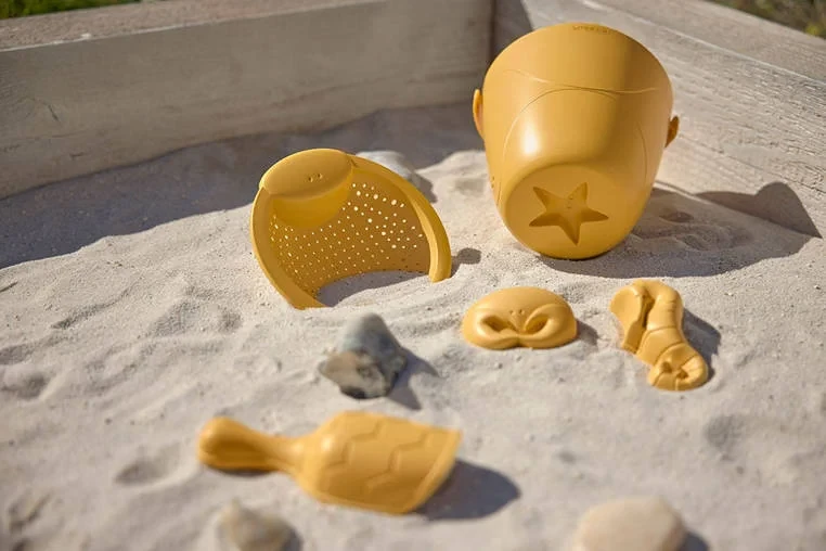 Dziecko bawiące się zabawkami do piasku Lassig Water Friends na plaży