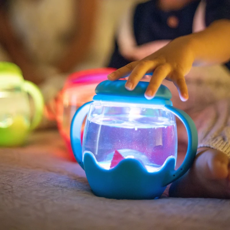 Dziecko bawi się mini słoikiem sensorycznym Glo Pals świecącym po napełnieniu wodą