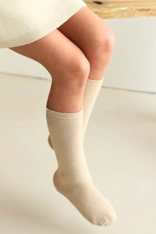 beżowe podkolanówki dziecięce Mama’s Feet na nodze dziecka