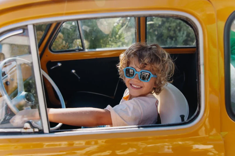 Niebieskie okulary przeciwsłoneczne Hello Hossy dla dzieci na modelu