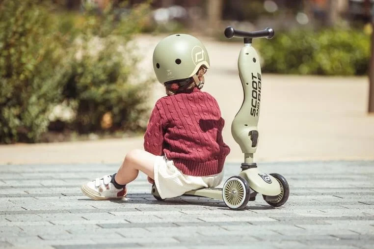 Kask ochronny Scoot and Ride Olive dla małego dziecka podczas jazdy