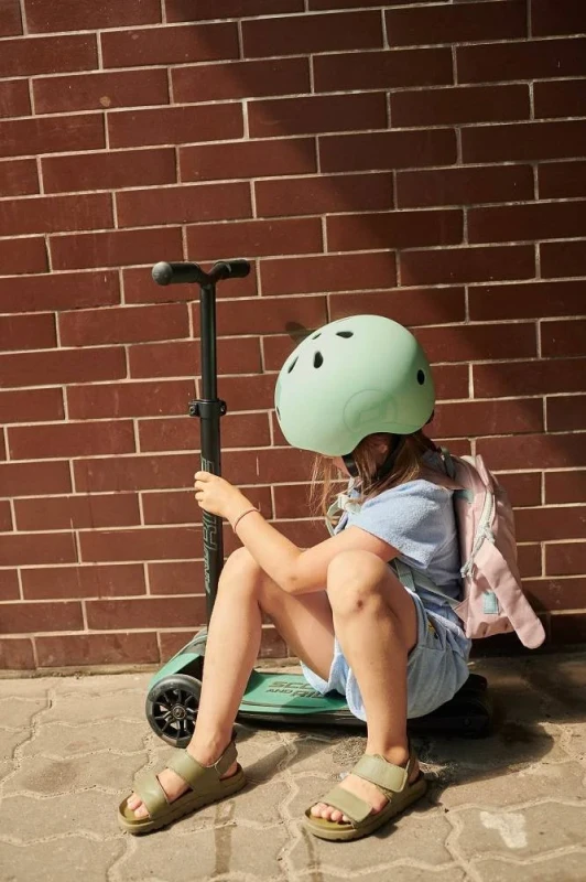 Dziewczynka siedząca przy hulajnodze Scoot and Ride Forest