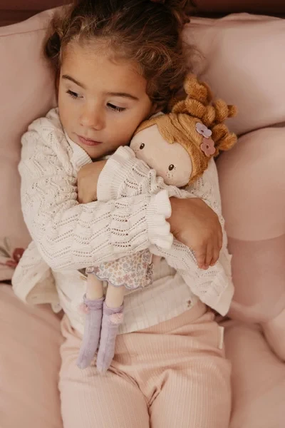 Dziewczynka przytula lalkę Ava Little Dutch podczas odpoczynku