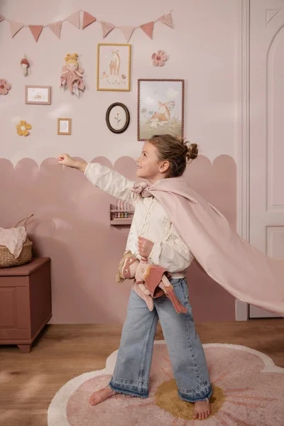 Dziewczynka bawi się lalką Superhero Rosa Little Dutch w pokoju dziecięcym