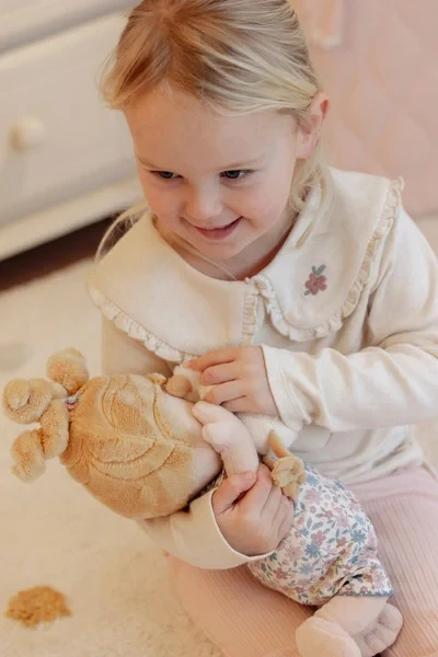 Dziecko trzyma lalkę Julia Little Dutch podczas zabawy