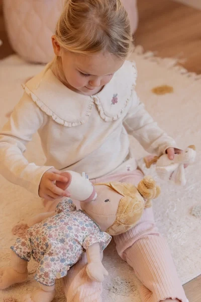 Dziewczynka karmi lalkę Julia Little Dutch butelką