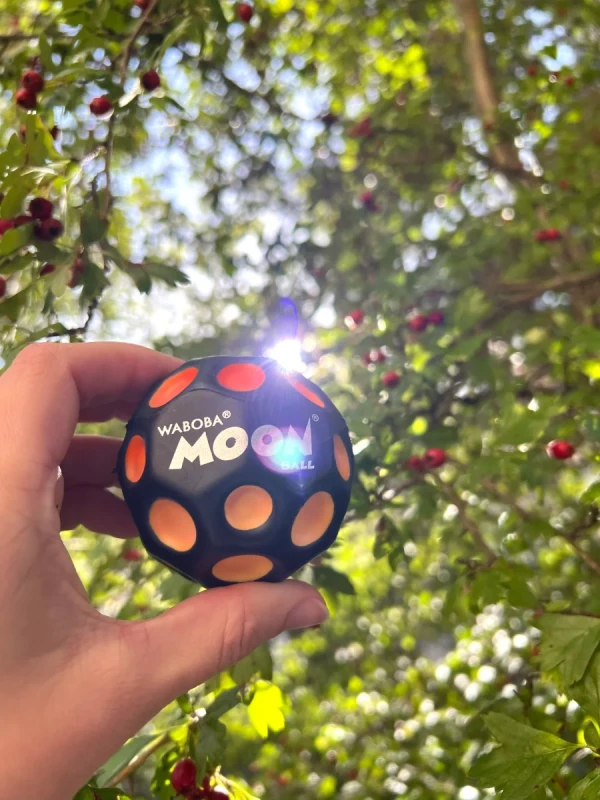 Piłeczka Waboba UV Moon Ball zmieniająca kolor na słońcu trzymana w dłoni