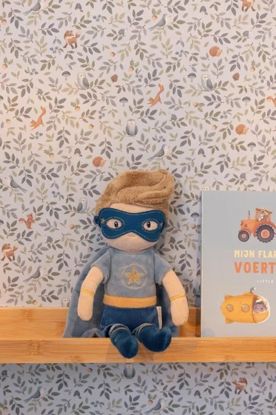 Dziecko leży z lalką Superhero Jim Little Dutch