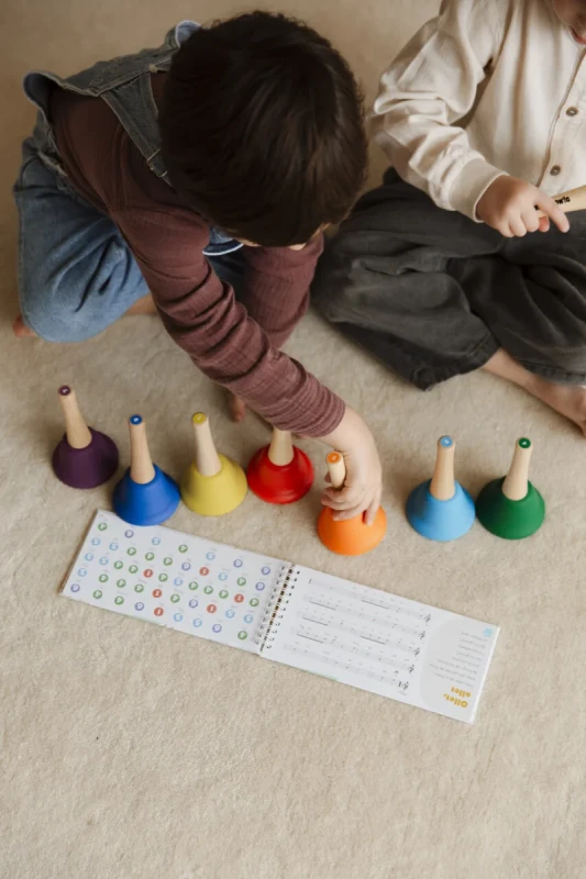 dziecko układające kolorowe dzwonki muzyczne edukacyjne DingdangBu Bells