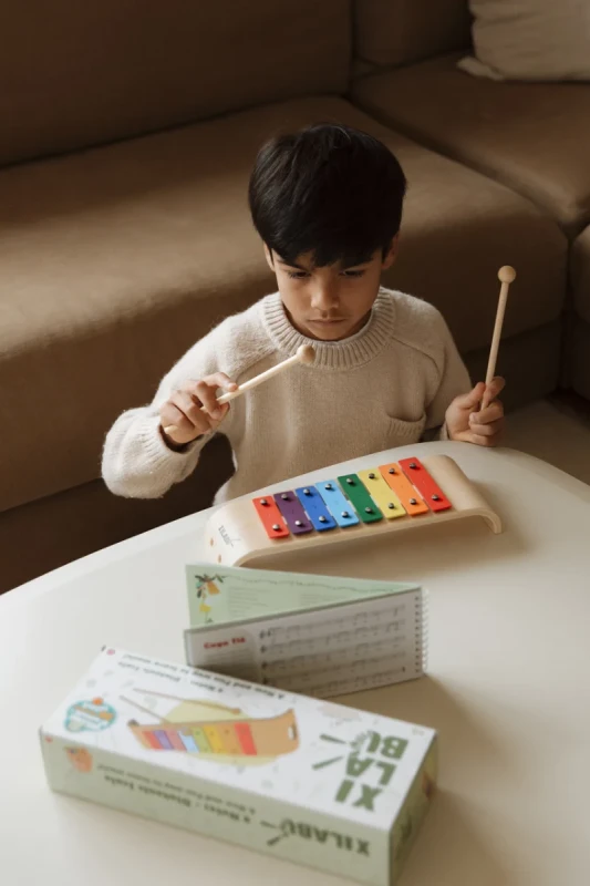 dziecko grające na drewnianym ksylofonie edukacyjnym XilaBu