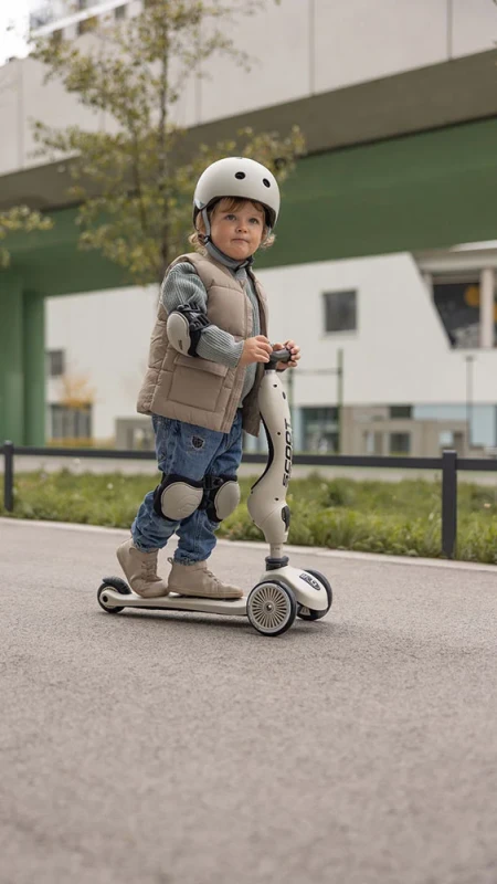 dziecko w ochraniaczach Scoot & Ride podczas jazdy na hulajnodze