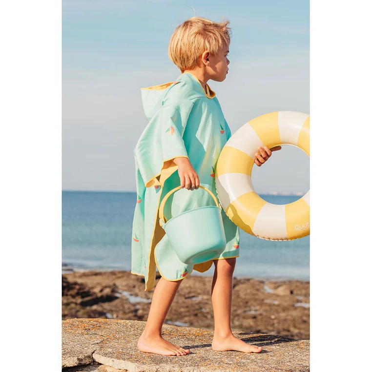 Dziecko w poncho QUUT Banana Blue z kołem do pływania na plaży