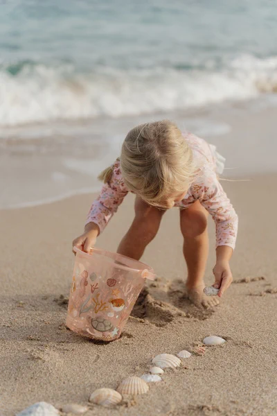Dziecko bawiące się wiaderkiem Little Dutch Pink Ocean Dreams na plaży