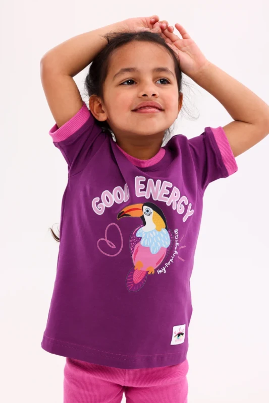 dziewczynka w fioletowym t-shircie z tukanem good energy hey popinjay