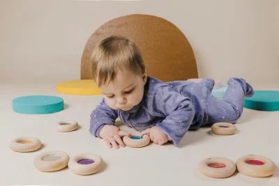 Drewniany donut sensoryczny Petit Boum z turkusowym wypełnieniem