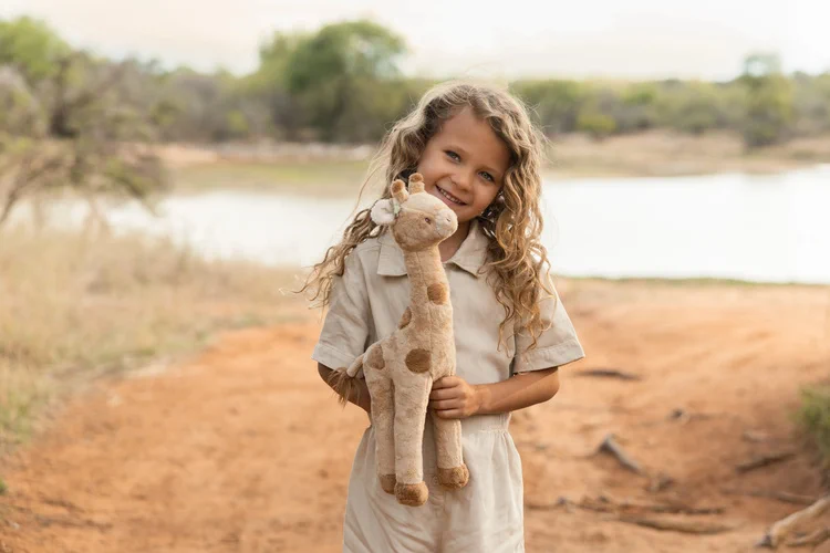 Dziecko trzyma przytulankę żyrafę Little Dutch Safari Friends