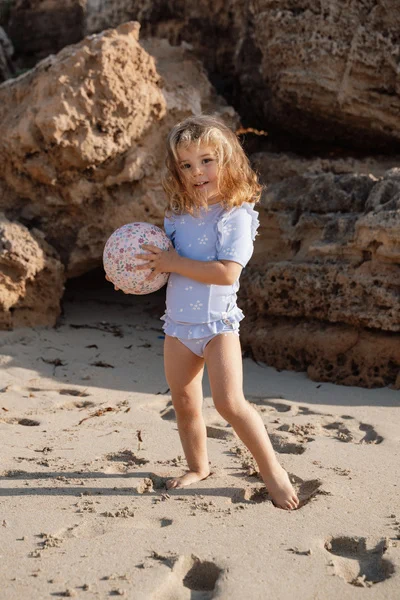 Dziewczynka bawi się mini piłką Little Dutch Dreamy Mermaid na plaży