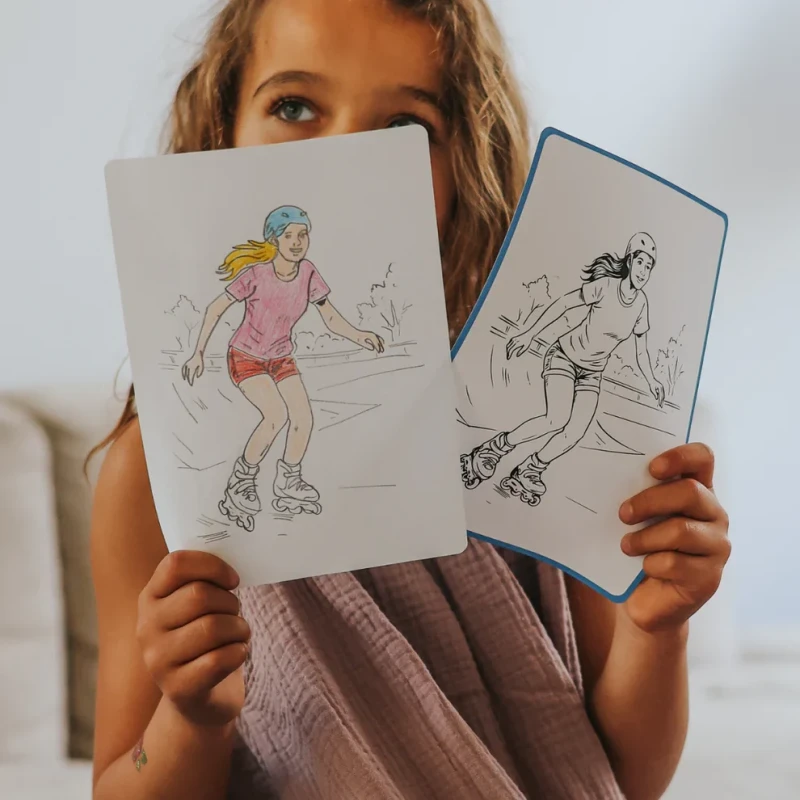 Dziecko pokazujące odrysowaną ilustrację jazdy na rolkach KIDYDRAW PAD
