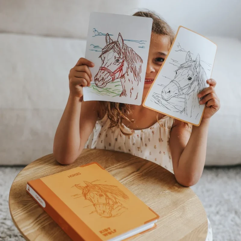 Dziecko pokazujące pokolorowany rysunek konia KIDYDRAW PAD