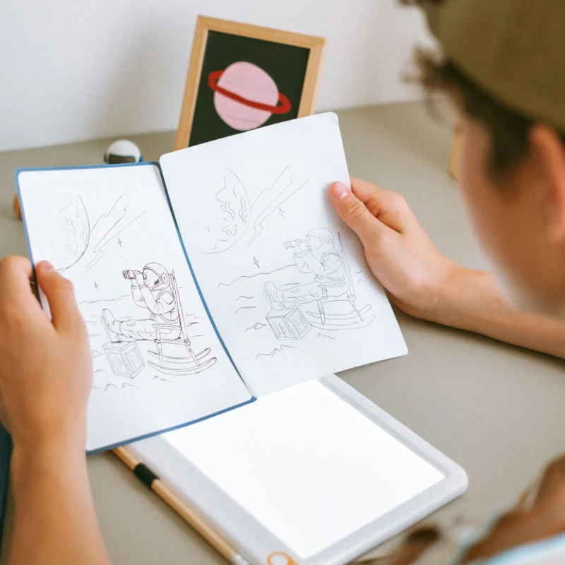 Dziecko porównujące odrysowaną ilustrację astronauty KIDYDRAW PAD Galaxy